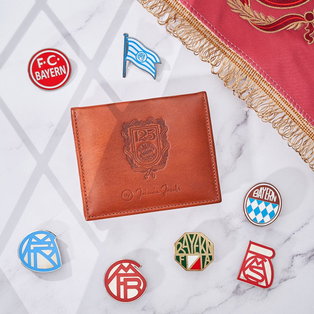 flap boy wallet fc bayern muenchen edition liegt auf einem tische neben fc bayern logos